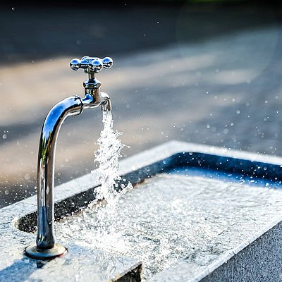 Klares Wasser fließt aus einem Steinbrunnen