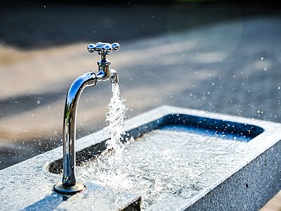 Klares Wasser fließt aus einem Steinbrunnen